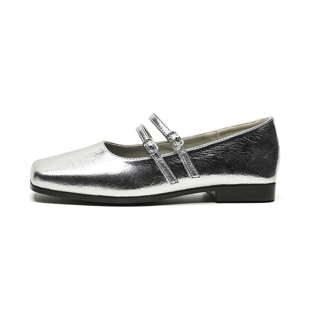 Women's silver leather ballet flats with a cross buckle strap, round toe, and low flat heel.