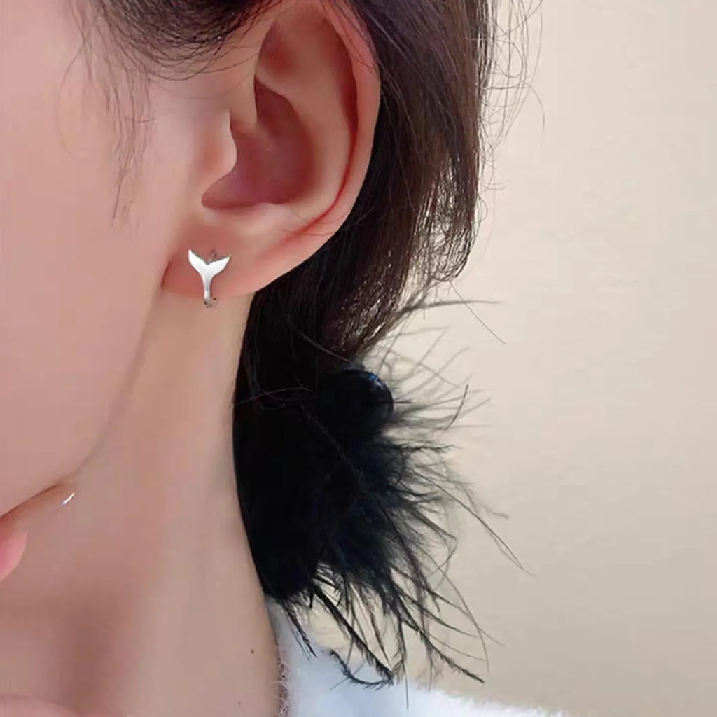 A pair of simple women's fishtail earrings with an electroplated finish in white gold or yellow gold colour.