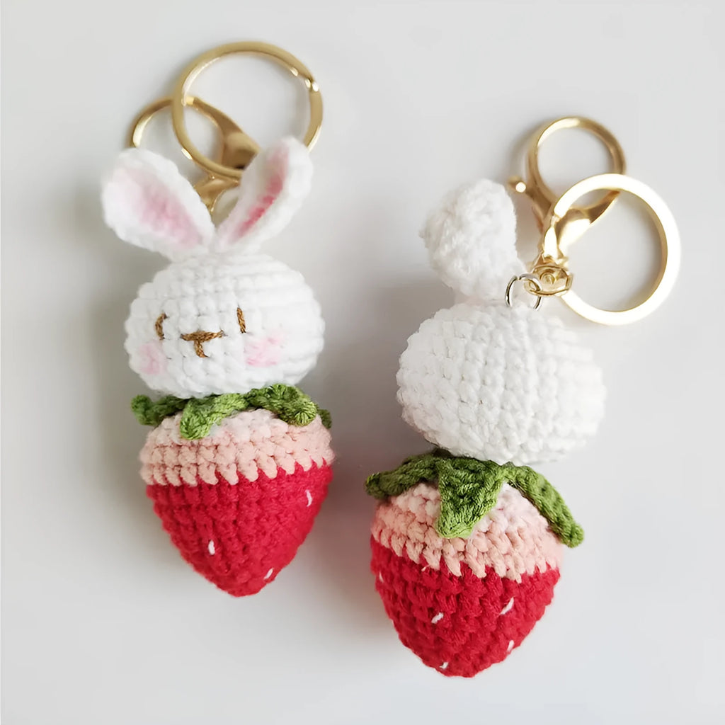 White hand-woven wire pendant with rabbit and strawberry design on a key fitting.
