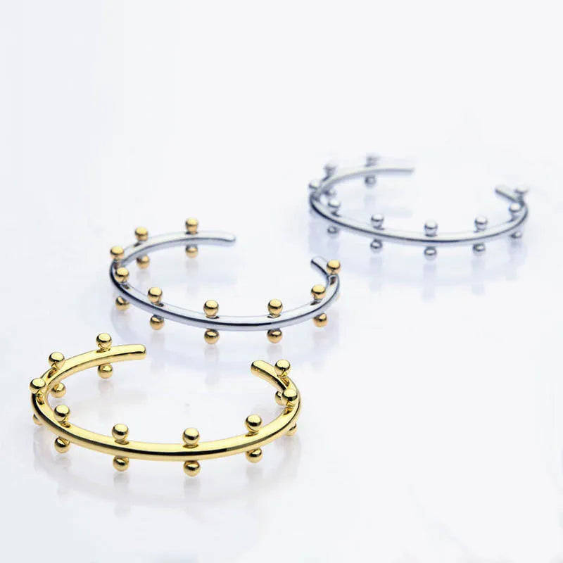 C-shaped stainless steel bean bead bracelet with textured finish and rivet detailing