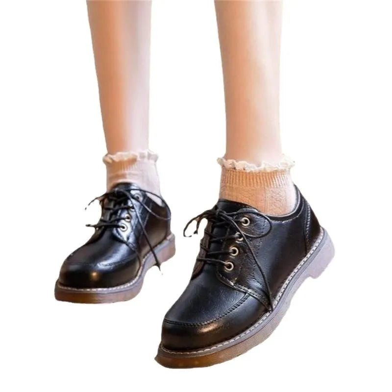 Women's black preppy style low-heel Mary Jane shoe with front lace-up and round toe on a white background.