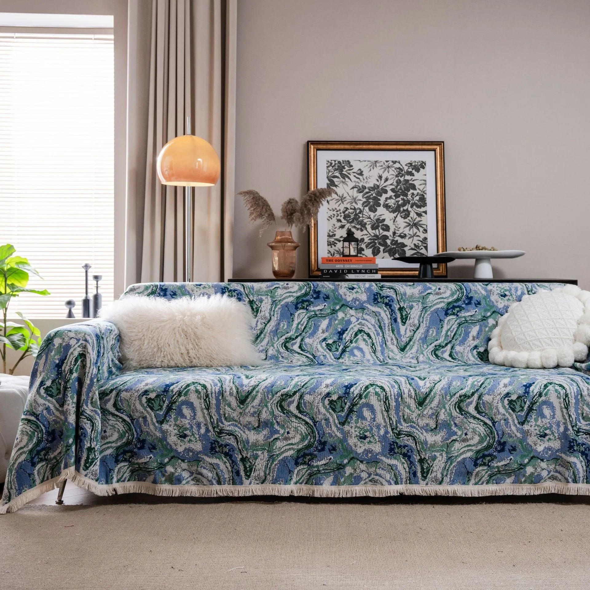 American country style jacquard patterned sofa cover in a green colourway draped over a sofa.