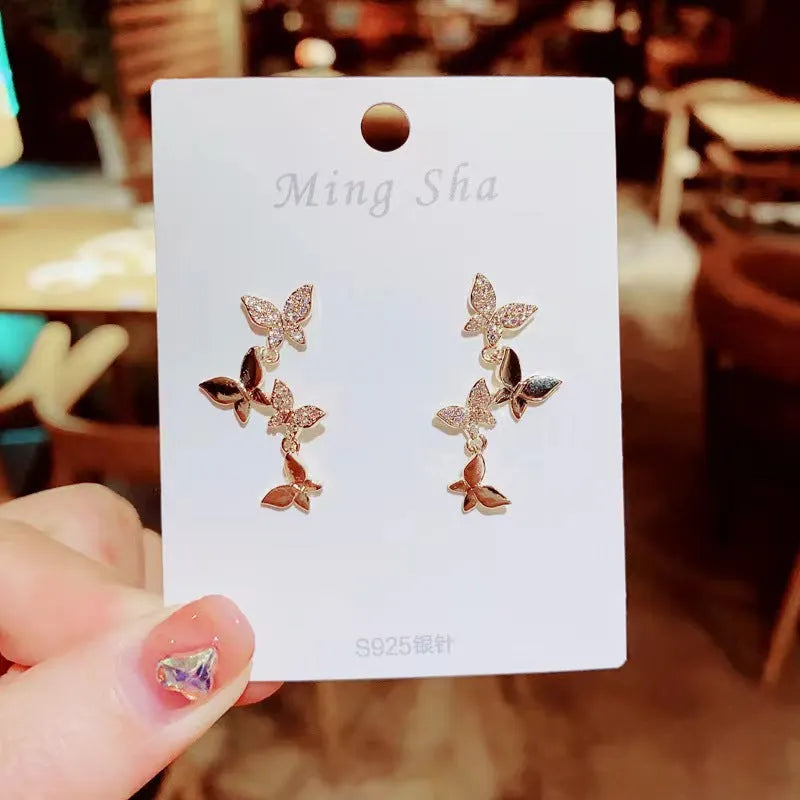 Women's copper butterfly drop earrings with four-butterfly design in gold colour