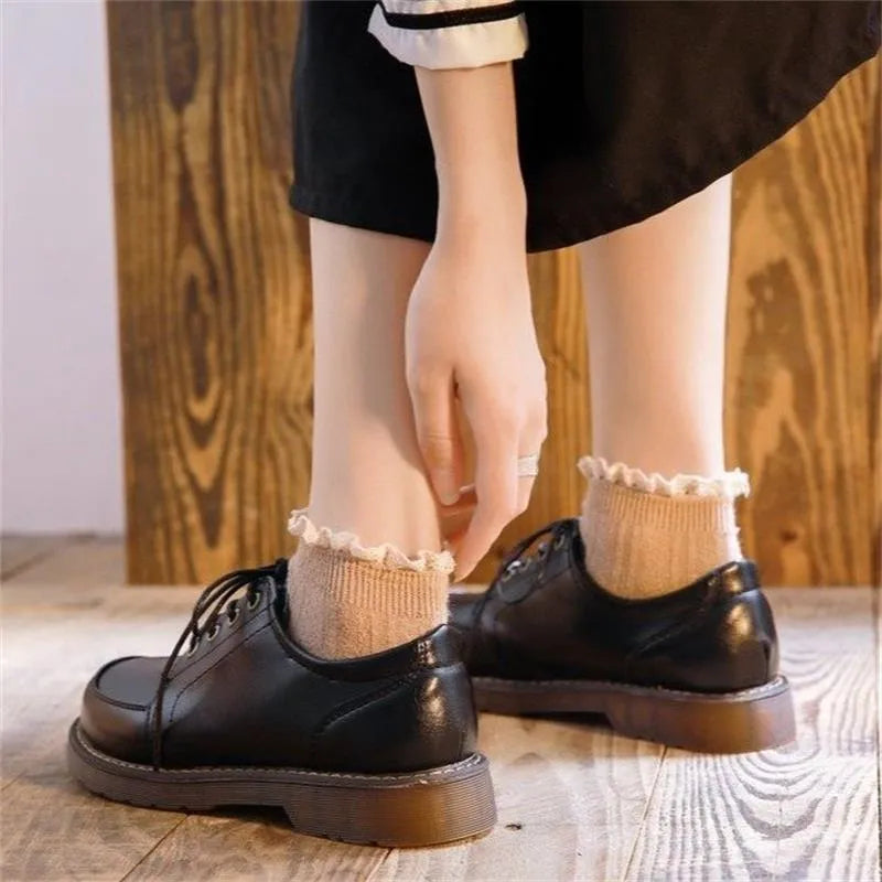 Women's black preppy style low-heel Mary Jane shoe with front lace-up and round toe on a white background.
