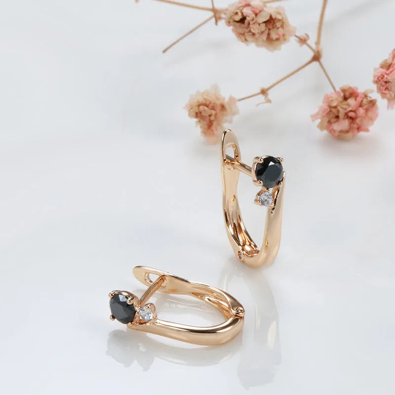 Gold coloured drop earrings with black agate stone centre and geometric design on copper settings