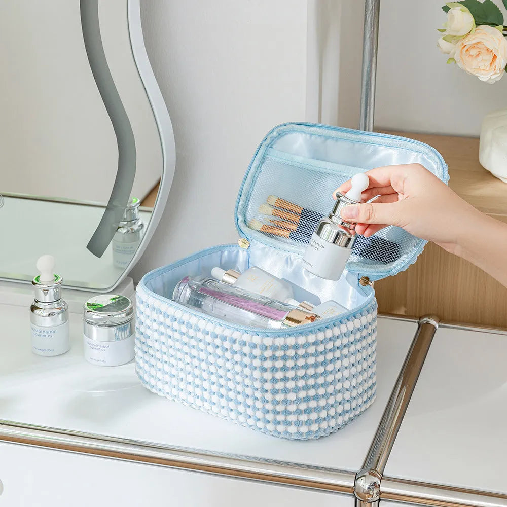 Four cube-shaped makeup bags in matching colour sets for travel cosmetic organisation