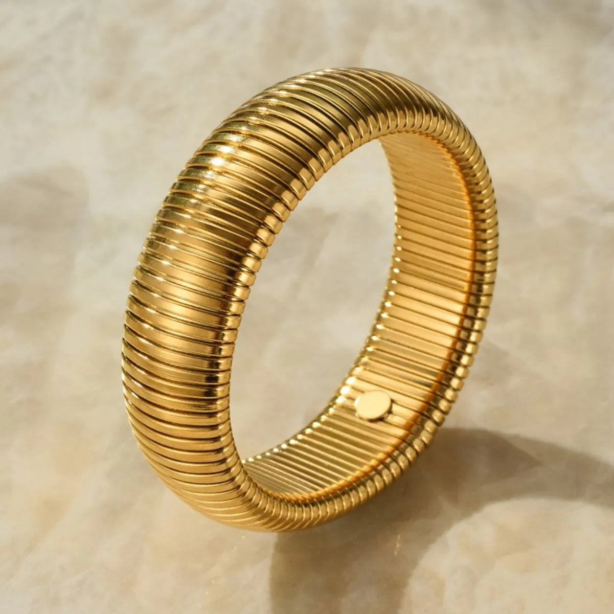 Women's titanium steel bracelet with vertical stripes in gold finish, elastic ring design