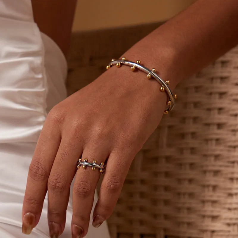 C-shaped stainless steel bean bead bracelet with textured finish and rivet detailing
