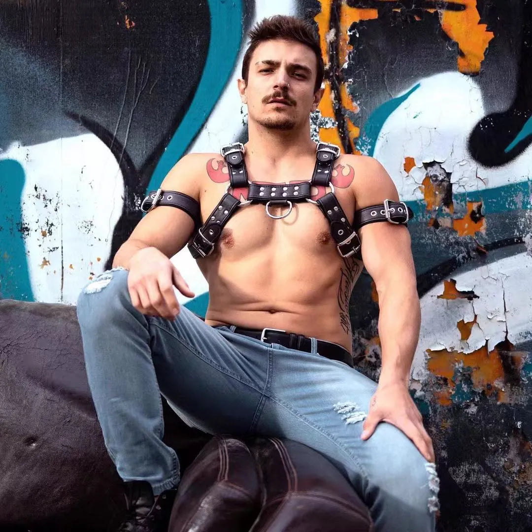 Black leather chest harness strap with metal buckles for men's bondage costume.