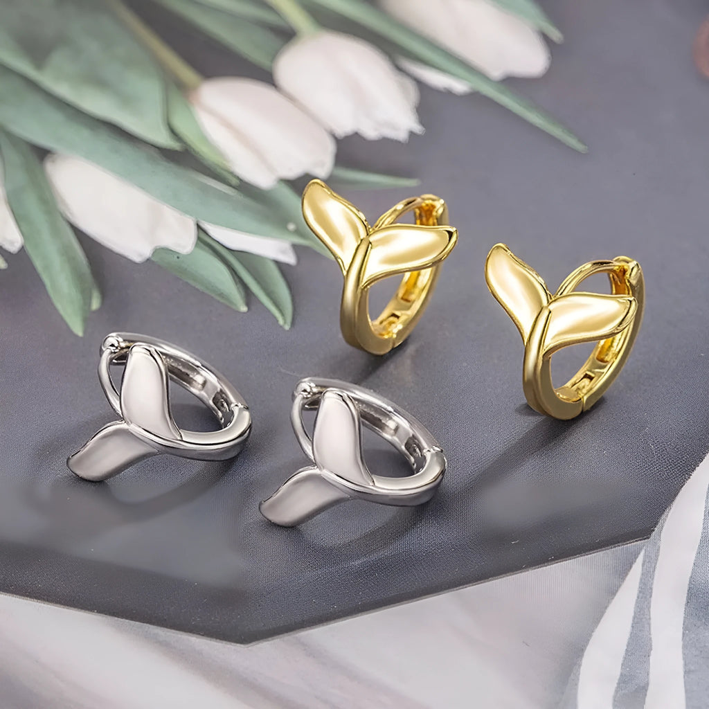 A pair of simple women's fishtail earrings with an electroplated finish in white gold or yellow gold colour.