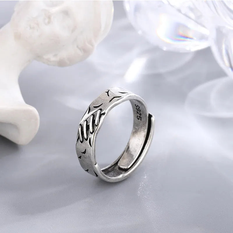Black copper geometric adjustable ring with round and oval shapes on a white background