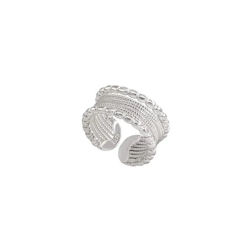 Geometric copper alloy ring with woven twisted design and adjustable opening.