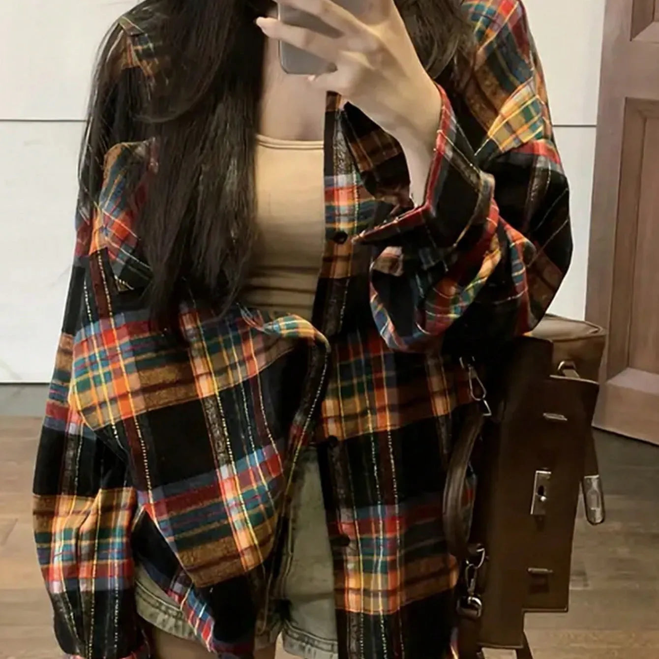Women's loose fit black and green plaid cotton shirt with long sleeves on a hanger.