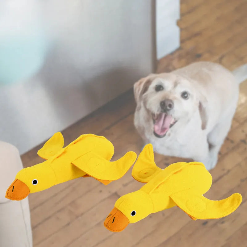Yellow plush teddy duck dog training toy with squeaker and treat dispensing compartment.