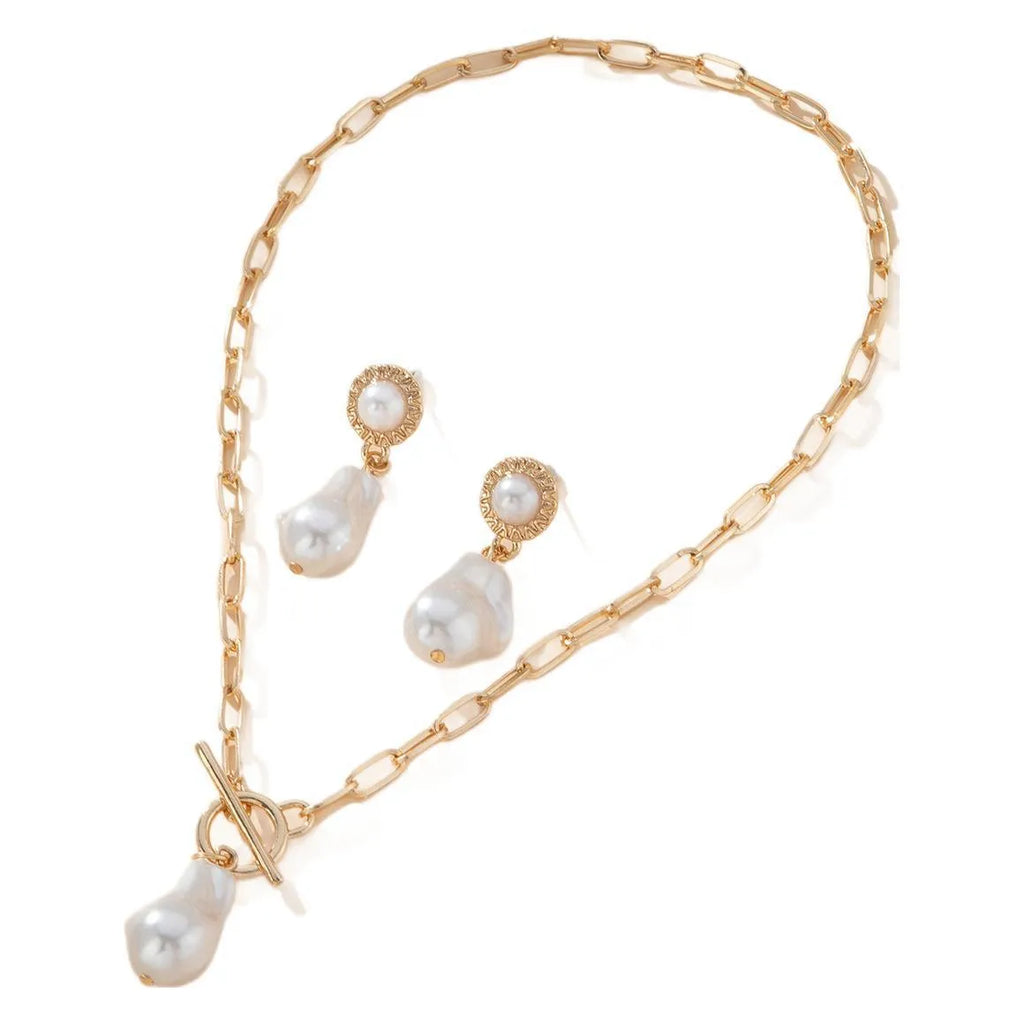 Gold retro baroque style necklace and earring set with pearl details on a white background.