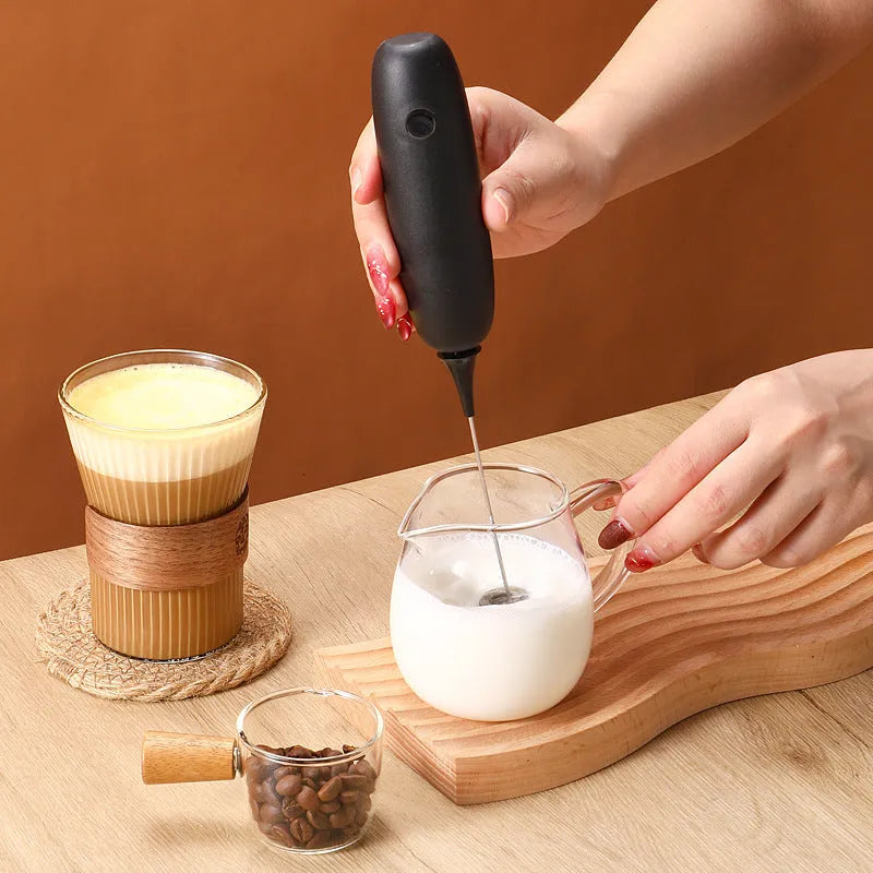 Black and white hand-held electric milk frother blender for coffee beverages