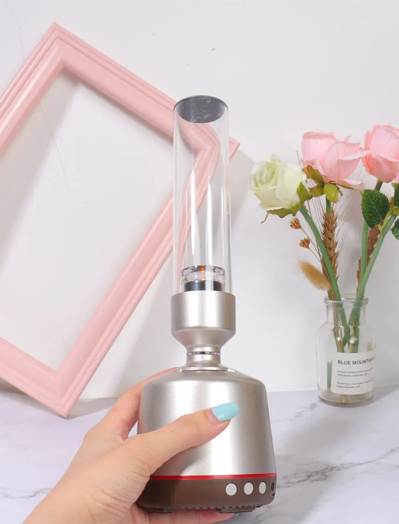 White silver candlelight Bluetooth speaker and night light on a table, showing modern cylindrical design.
