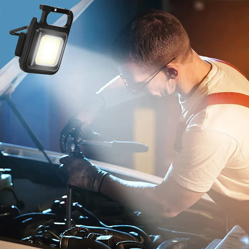 Black aluminium alloy keychain light with COB LED, magnetic base, and foldable handle on keyring