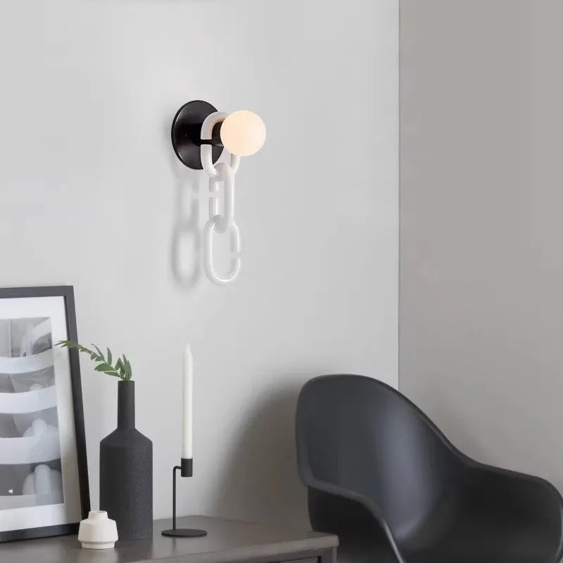 Simple glass ball bedroom wall lamp with black base and milky white chain, warm LED light