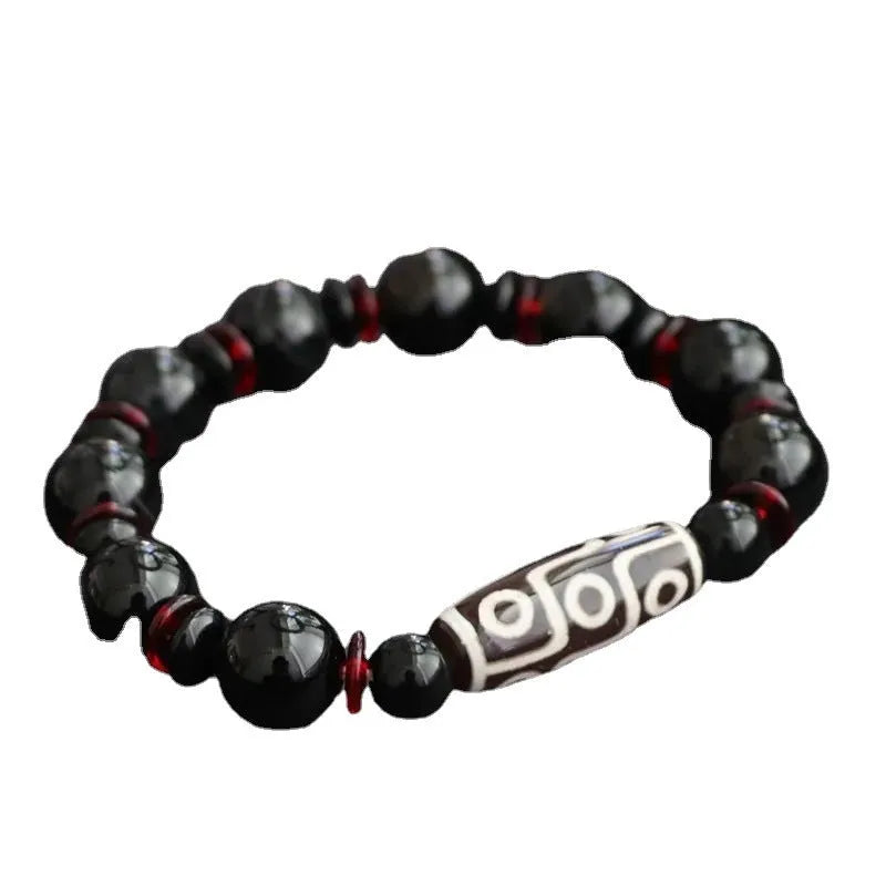 Hand-woven black agate Dzi bead bracelet on a wrist, showing geometric bead and woven band.