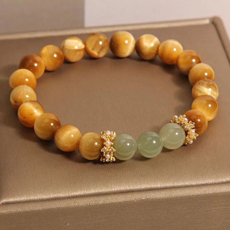 Natural yellow tiger's eye Hetian jade bracelet with diamond polish and auspicious pattern on white background