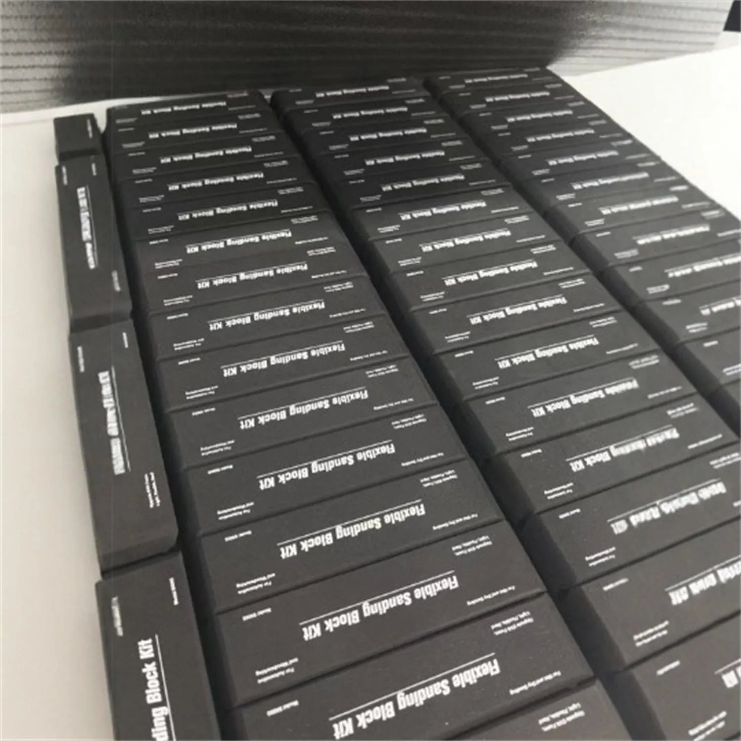 Set of seven black frosted metal alignment blocks for workshop use.