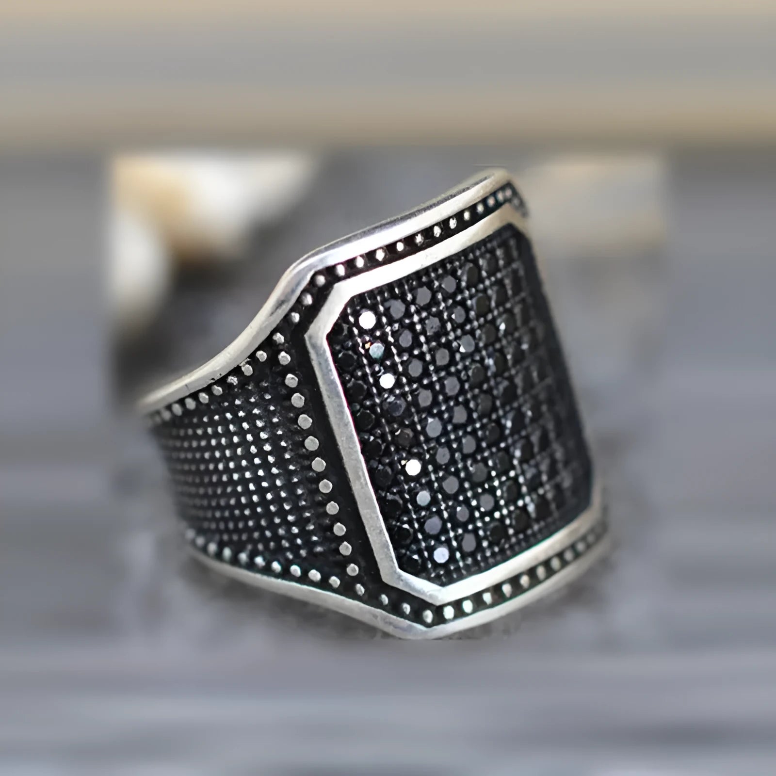 Black alloy ring with copper inlay and zircon stone, shown in unisex sizes 7 through 13.