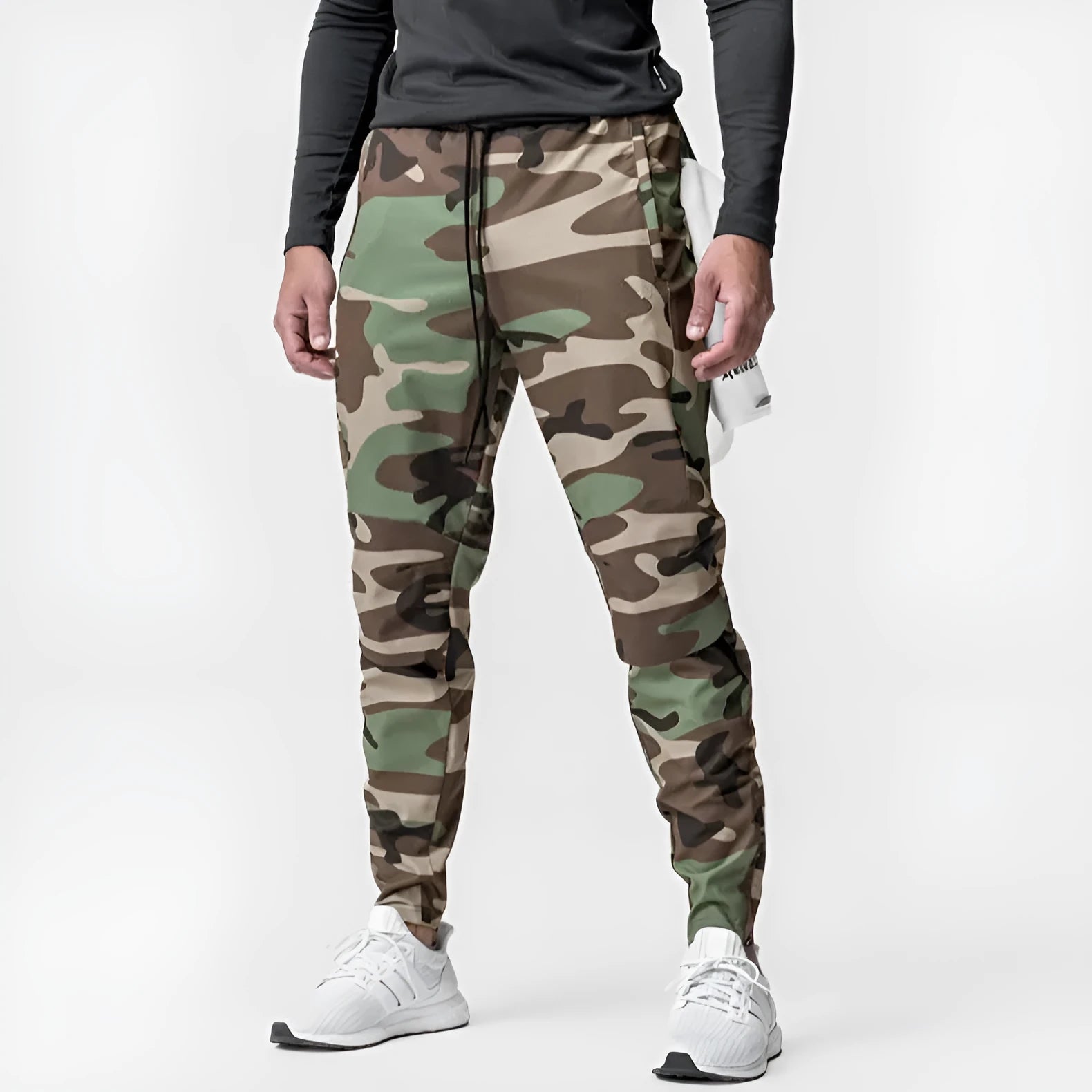 Man wearing dark grey quick-dry fitness trousers with ankle ties, suitable for running and gym workouts.