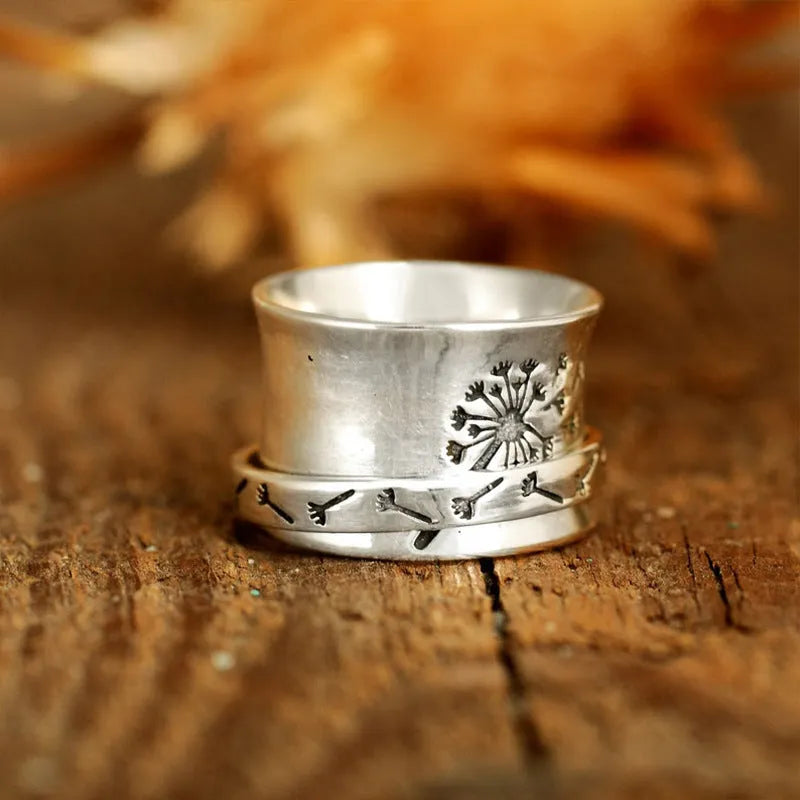 Silver rotating flower ring showing floral element and band details