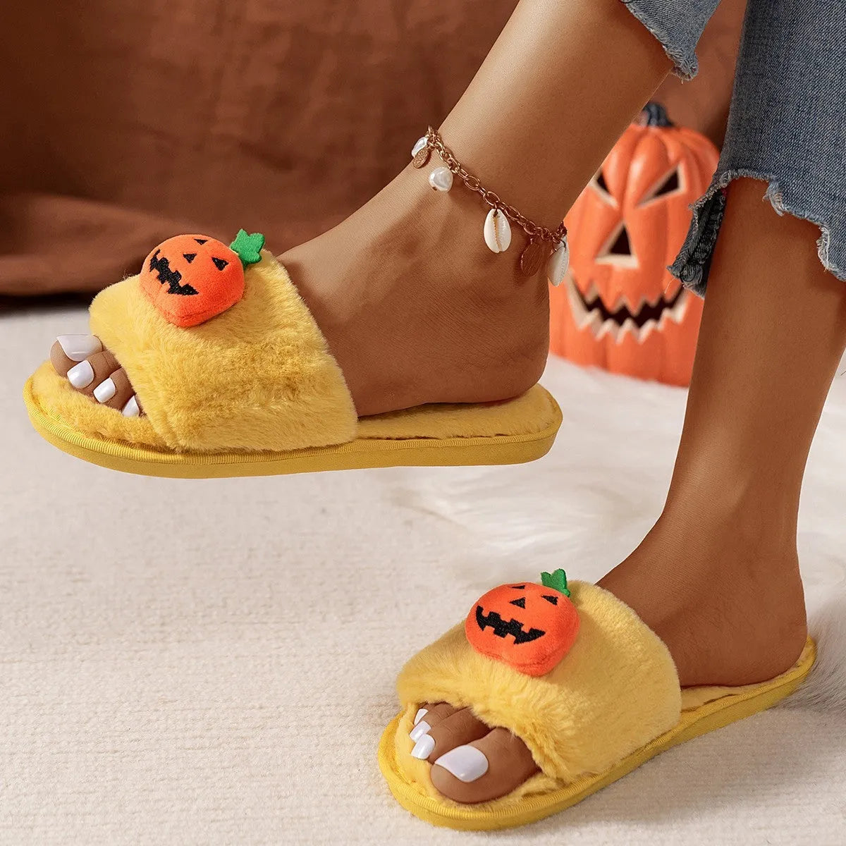 White and yellow pumpkin-themed plush open-toe slippers with a synthetic fur upper.