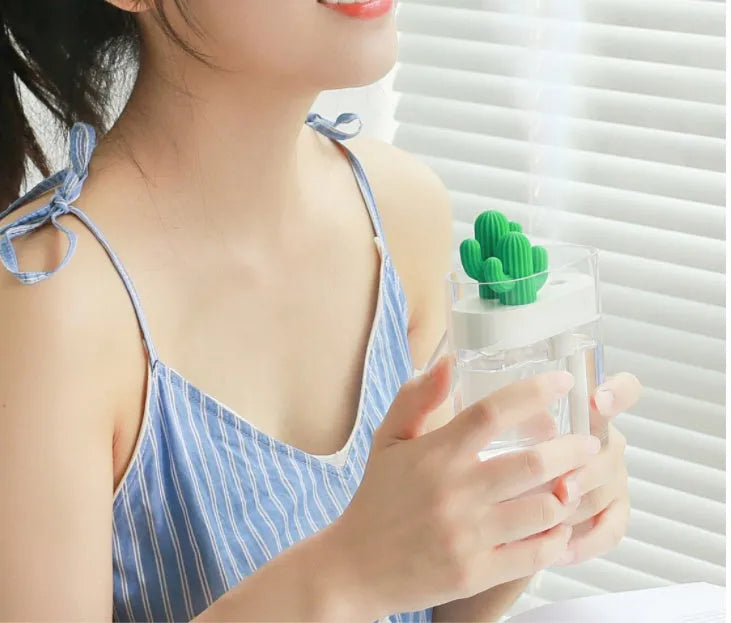 Transparent green cactus USB portable humidifier on desk showing water level inside plastic body