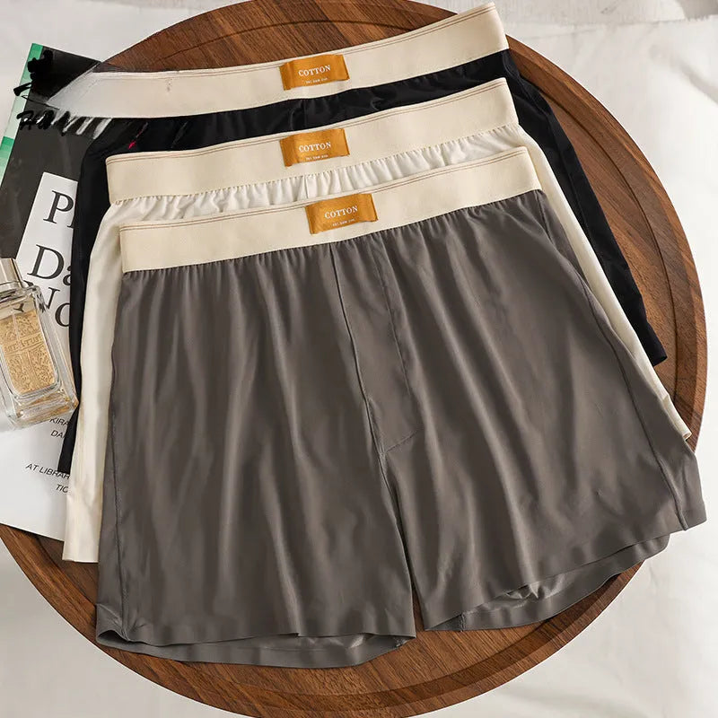 Pack of three pairs of solid colour men's loose fit ice silk underwear on a white background.