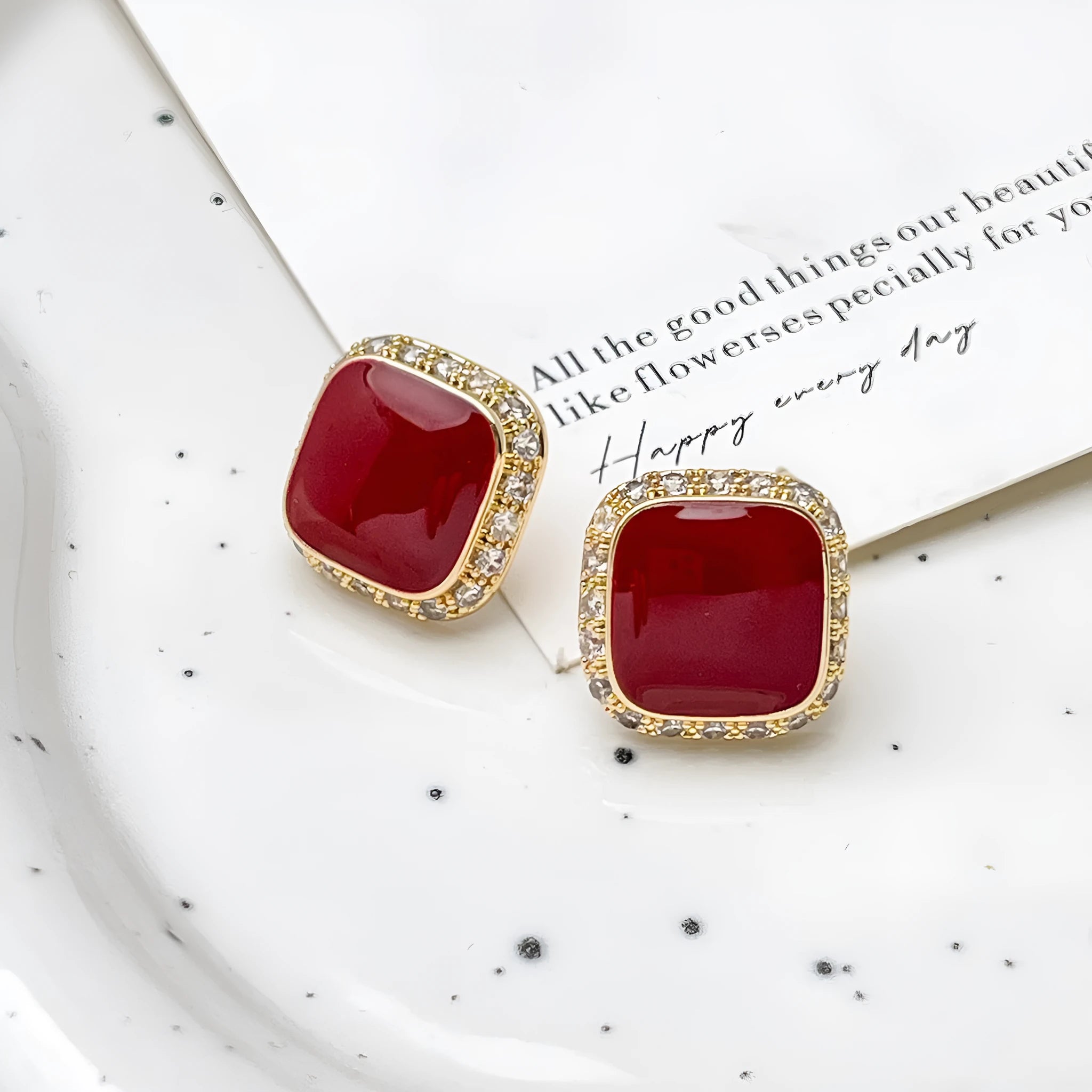 A pair of red geometric square alloy earrings with inlaid detailing on a white background.