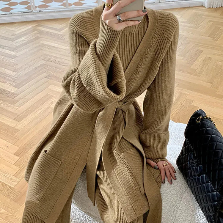 Women's knitted three-piece set showing apricot coloured wide-leg trousers, sweater, and cardigan with leather stitching