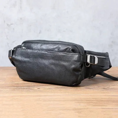 Men's small black head layer cowhide cross-body backpack with zip closure and single shoulder strap