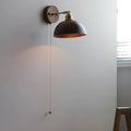 Inn Niche walnut-colour Nordic wall lamp mounted above a bedside table