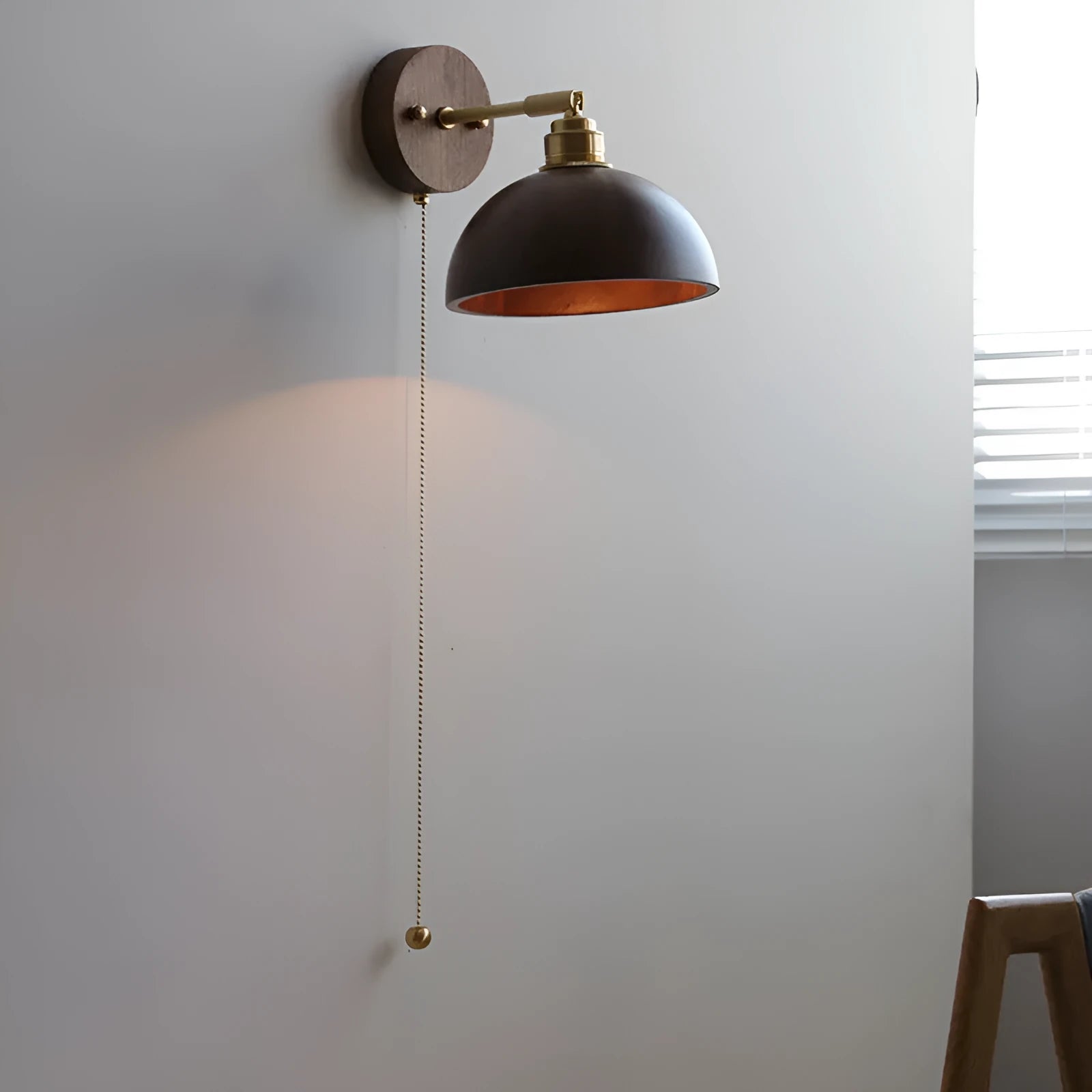 Inn Niche walnut-colour Nordic wall lamp mounted above a bedside table