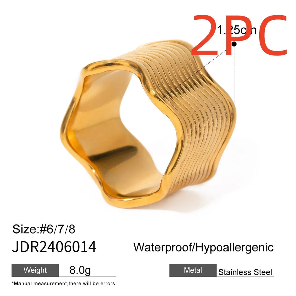 Stainless steel geometric wave pattern ring on a hand, showcasing its wide band and electroplated finish.