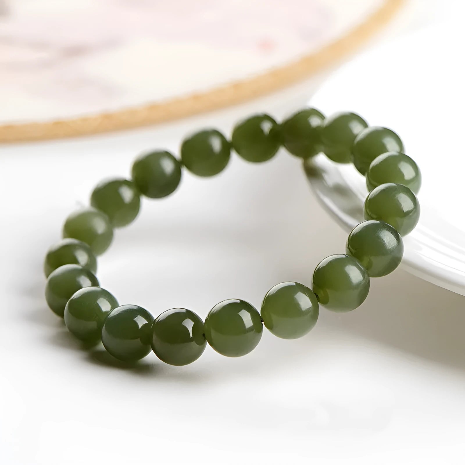 Polished Hetian jade ball bracelet in clear water colour on a wrist, showing spherical beads.