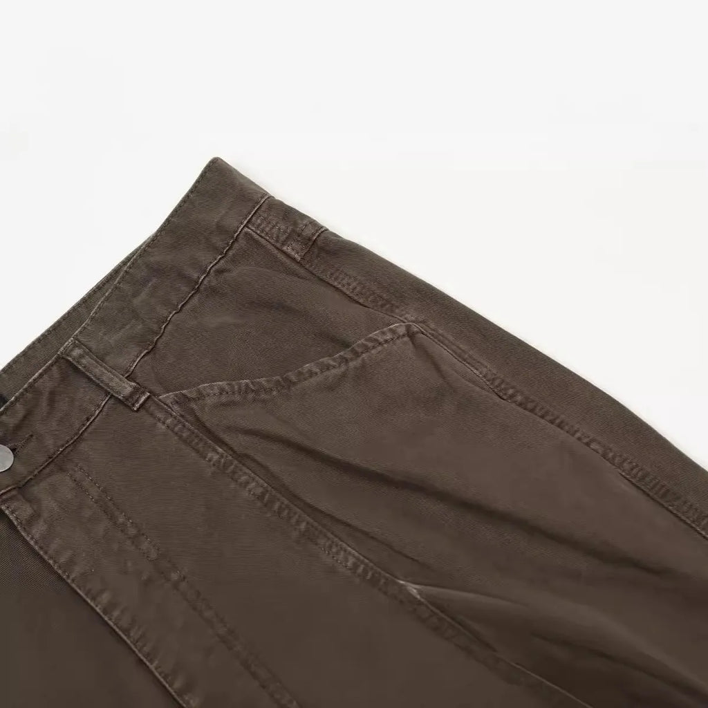 Men's brown loose straight-leg cotton trousers with a high waist and zipper fly.
