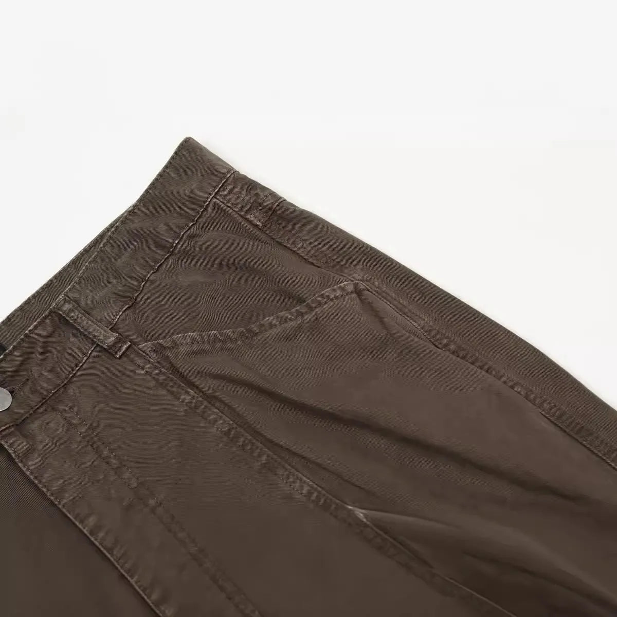 Men's brown loose straight-leg cotton trousers with a high waist and zipper fly.
