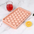 Blue silicone ice cube tray with lid showing 33 round ice cube moulds