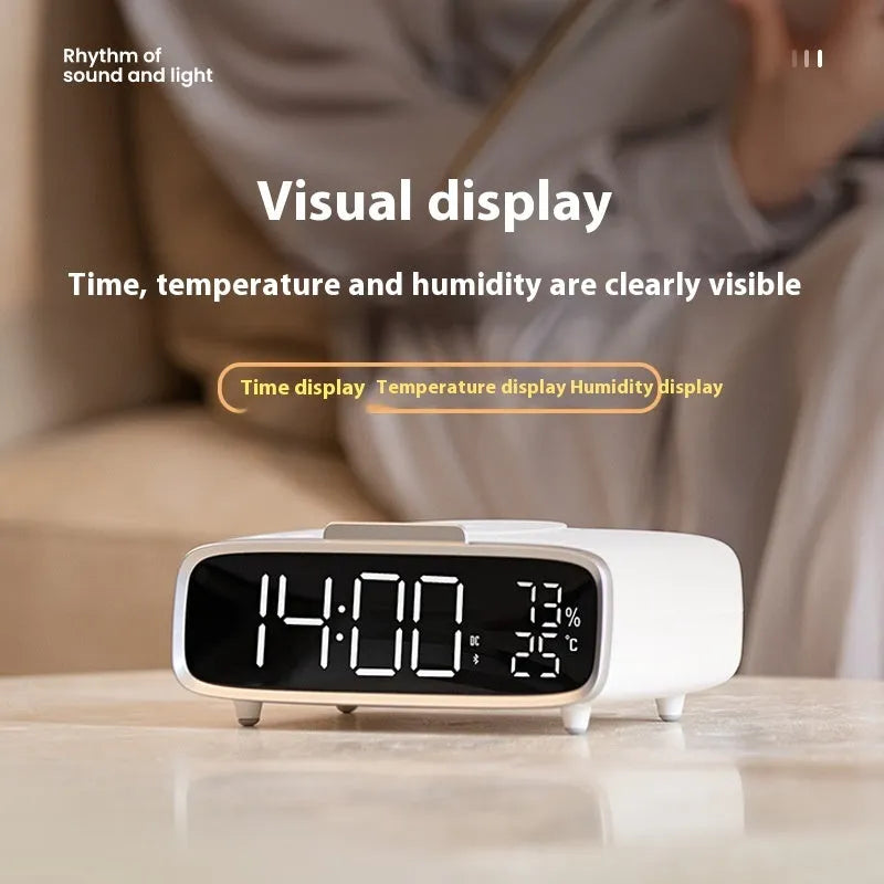 White ABS acrylic Bluetooth speaker wireless charger with night lamp and alarm clock on a desk showing charging pad and speaker grille