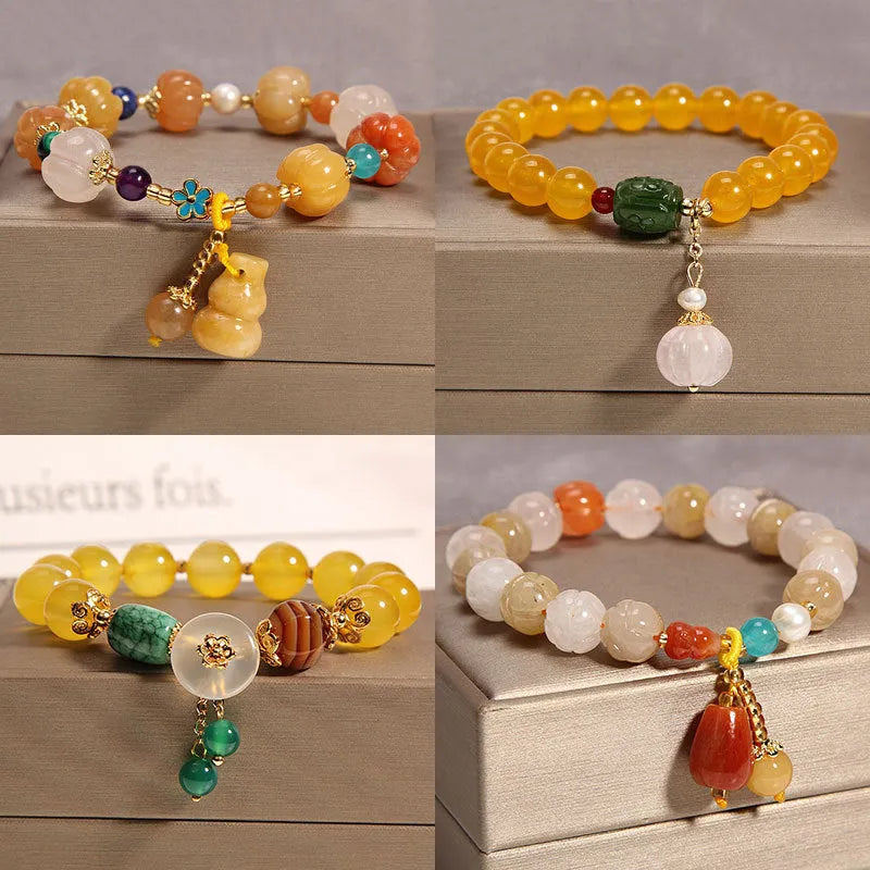 Close-up of a khaki yellow agate crystal bracelet with gold silk threading on a wrist.