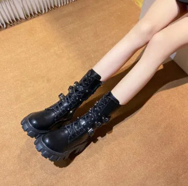 Black mid-calf women's boots with a prominent buckle detail and side zipper on a white background.