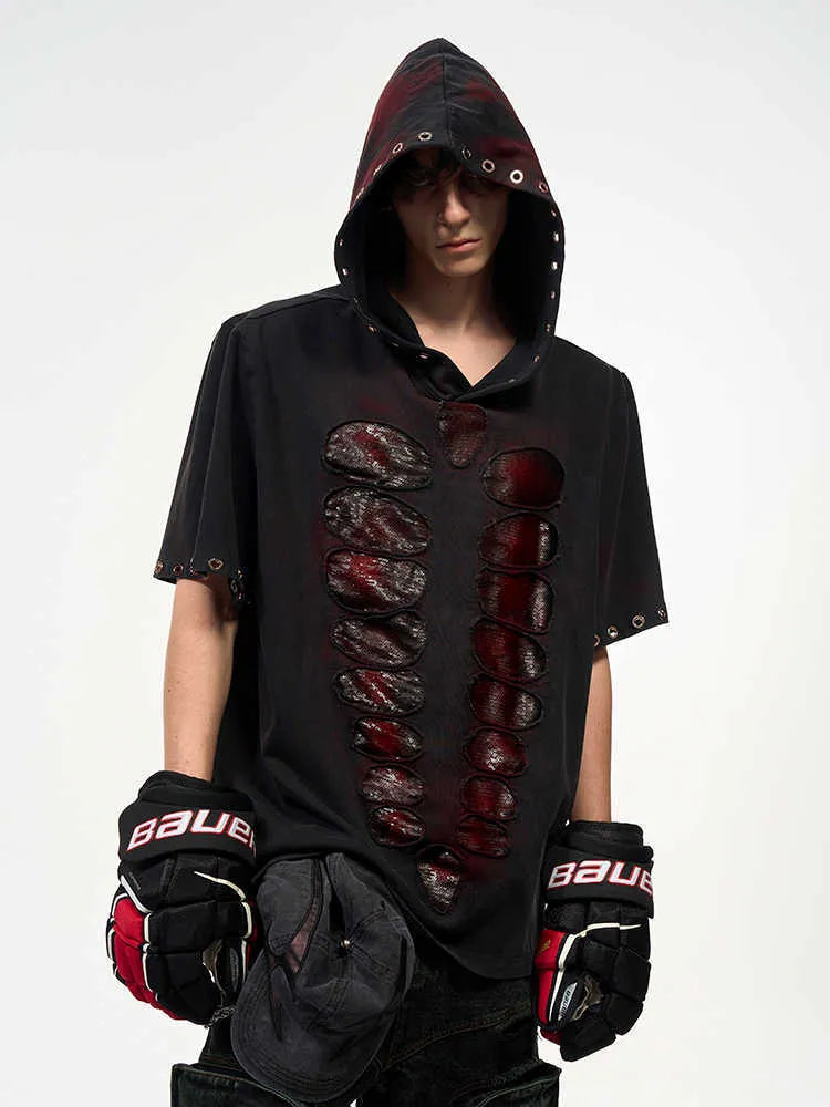 Man wearing a black hooded T-shirt covered in sequins, showing loose fit and short sleeves.