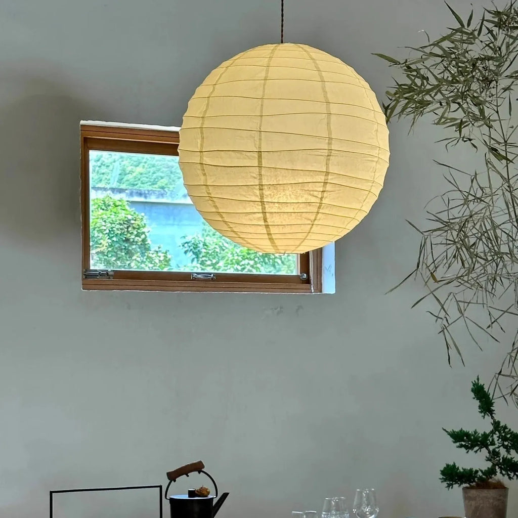 Japanese style rice paper pendant chandelier hanging from a ceiling, providing soft ambient light.