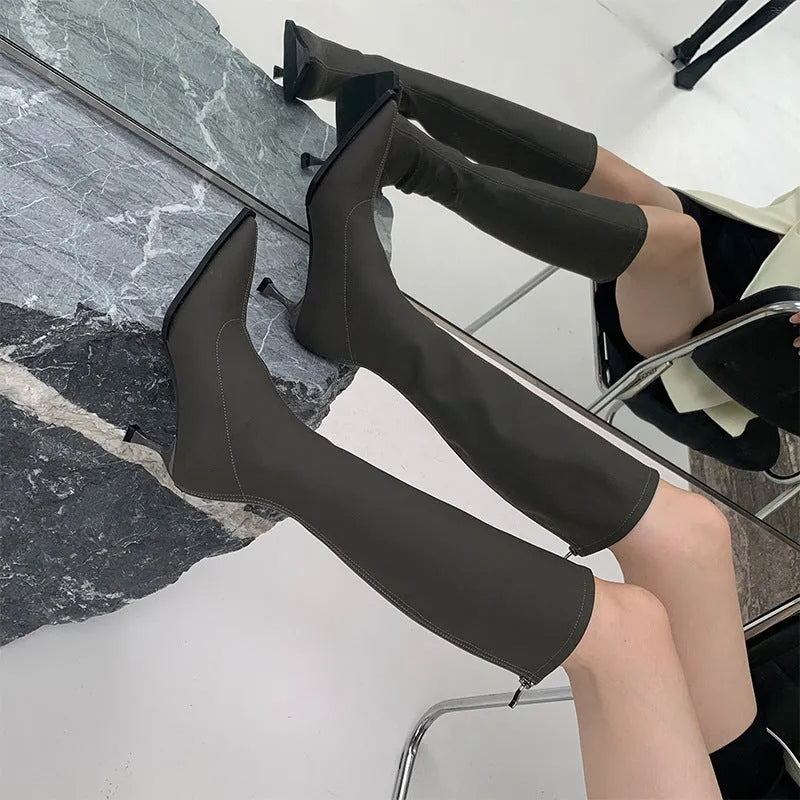 Black pointed toe stiletto heel boots with a back zipper, showing the below-the-knee shaft height.