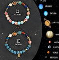 Set of twelve beaded bracelets with natural stones, each showing a different zodiac symbol on elastic cord.
