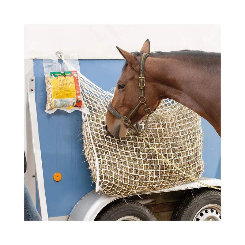 Woven PE rope horse feeding bag with grid pattern in black colour, shown hanging with hay